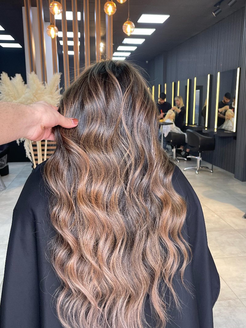 Donker golvend haar met koperen tinten, van achteren